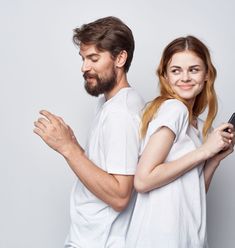 a man and woman standing next to each other with their arms wrapped around one another