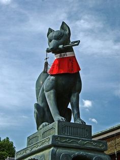 a statue of a dog wearing a red skirt and holding a leash in its mouth