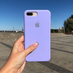 a hand holding an iphone in front of a blue sky with the back cover open