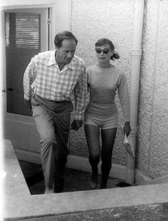 an older man and young woman walking down the stairs together in their bathingsuits