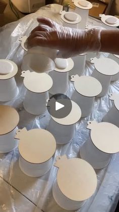 a table topped with lots of white plates and bowls on top of plastic wrapper