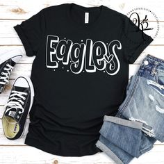 a t - shirt with the word eagles on it next to ripped jeans and sneakers