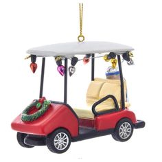 a red golf cart ornament hanging from a chain on a white background with christmas decorations