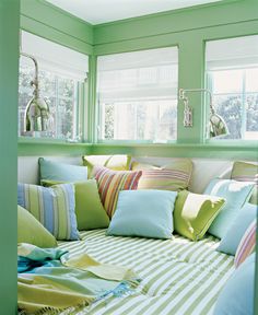 a room with green walls and lots of pillows