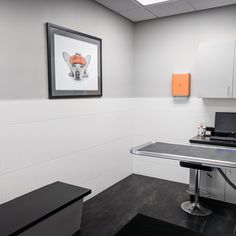 an office cubicle with a desk, laptop and printer on the wall next to it