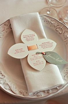 a white plate topped with two napkins covered in paper flowers and names on it