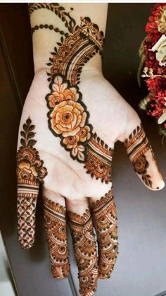 the hand is decorated with henna and flowers