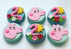 cupcakes decorated with pink and blue frosting are arranged in the shape of peppa pig