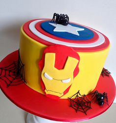 the cake is made to look like captain america's shieldman helmet with spider webs on it