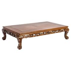 a wooden coffee table with carvings on the top and bottom, against a white background