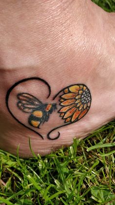 a small tattoo on the foot of a person with a heart shaped flower and butterfly