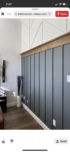 a room with wood floors and gray paneling on the walls, along with a wooden desk