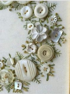 some white buttons and pine needles on a table