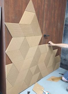 a man is working on a wall made out of cardboard