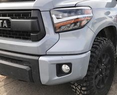 the front end of a silver truck parked in a parking lot