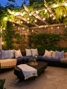 an outdoor living area with couches and lights