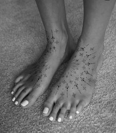 a woman's foot with flowers and stars tattooed on the bottom of her toes