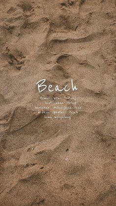 the words beach are written in white ink on brown sand, with footprints and small waves