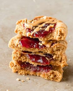 three peanut butter and jelly cookies stacked on top of each other