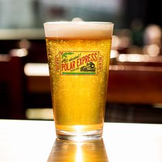 a glass of beer sitting on top of a table