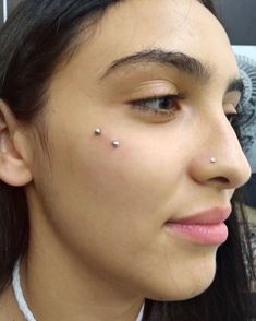 a woman with piercings on her nose looking at the camera