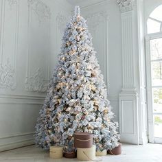 a white christmas tree with lights in a room