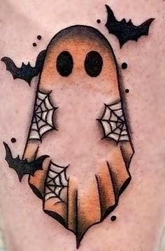 a halloween tattoo with a ghost and bats on it