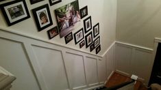 there are many pictures on the wall above the stairs