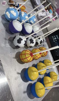 there are many cake pops with soccer balls on them and one is blue, yellow and white