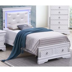 a white bed sitting in a bedroom next to a night stand and dresser with drawers