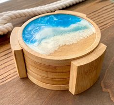 a wooden container with blue and white liquid in it sitting on top of a table