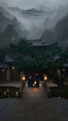 two people standing on a walkway in front of a tree with lanterns lit up at night