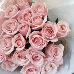 a bouquet of pink roses sitting on top of a table