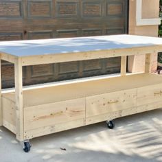 a large wooden table sitting on top of a driveway next to a garage door,