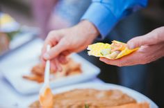 people are serving themselves food from plates on the table