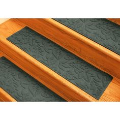 the stair treads are made from wood and have green rubber mats on each side