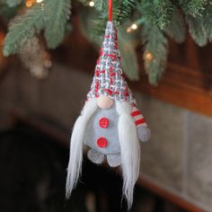 an ornament hanging from a christmas tree decorated with red and white decorations,