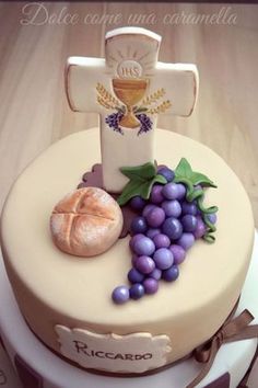 a cake decorated with grapes, bread and a cross