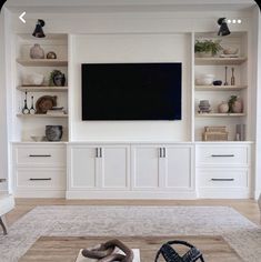 a living room filled with furniture and a flat screen tv mounted on the wall above it