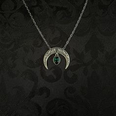 "This simple pendant features a richly detailed antiqued silver tone crescent, adorned with dazzling emerald green glass crystals. Pendant is 1 1/8\" wide and 1\" tall.  Necklace length is adjustable with soldered stainless steel cable chain, lobster clasp and extender. If you would like a different length, please send us a message. Matching headpiece, pendant and earrings are listed separately in our store. If you don't see items with a color you want, feel free to ask about availability." Gothic Crescent Moon Charm Jewelry, Green Crescent Moon Charm Jewelry, Gothic Silver Crescent Necklace, Gothic Crescent Silver Necklace, Gothic Crescent Moon Phase Jewelry, Gothic Green Jewelry For Gifts, Green Gothic Jewelry For Gifts, Green Gothic Jewelry Gift, Green Gothic Style Jewelry Gift