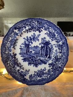 a blue and white plate sitting on top of a counter next to a light fixture