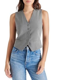 This little vest is pretty much perfect! Crafted in a gray pinstripe, it features a button closure front and minimal elastic cinch in back. Pinstripe, V-neck, button down. Form-fitting and slightly cropped. Faux-welt pockets. Rayon, Elastane, Polyester. Model is wearing a size S. Pinstripe Vest, Stripe Vest, Gray Vest, Striped Vests, Tiered Maxi Skirt, Grey Vest, Knit Bottom, Woven Top, Cream Dress