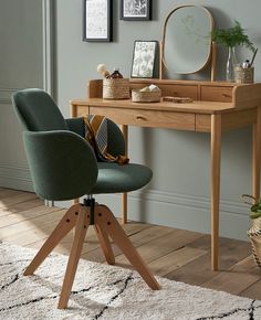 a desk with a chair, mirror and pictures on the wall in front of it