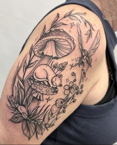 a woman's arm with mushrooms and flowers tattoo on the left side of her body