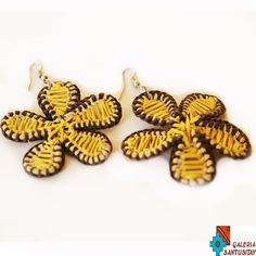 some brown and yellow earrings on a white surface with words below it that says, i love you