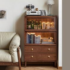 a living room with a couch, chair and book shelf in it's corner