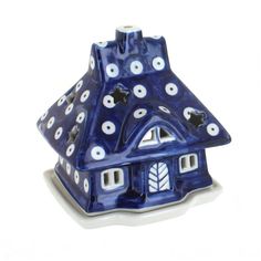 a blue and white ceramic house ornament with stars on it's roof