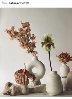 there are several vases with flowers in them