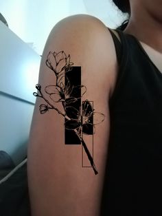 a woman's arm with a cross and flowers tattoo on the back of it