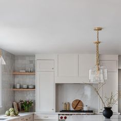 a kitchen with marble counter tops and white cabinets